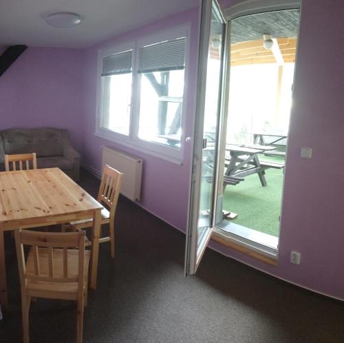 a dining room with a table and a glass door at Lucky apartmán in Svoboda nad Úpou