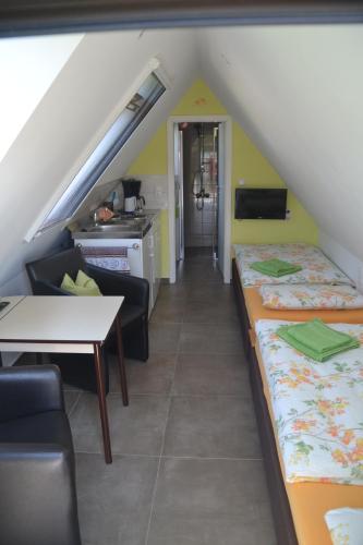 a attic room with two beds and a table at Radlerwohnung bei Familie Saupe in Schaprode