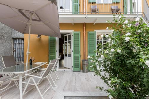 a patio with a table and chairs and an umbrella at Residenza La Zagara in Cannero Riviera