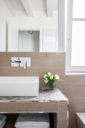 a bathroom with a sink and a vase of flowers on a counter at Residenza La Zagara in Cannero Riviera