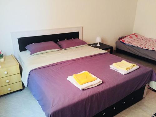 a bedroom with a large bed with two towels on it at Khan Alsira - חאן אלסרה in Alsira