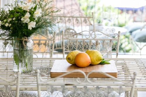 a plate of fruit on a table with a vase of flowers at Residenza La Zagara in Cannero Riviera