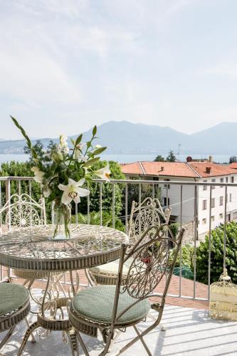 a table with chairs and a vase of flowers on a balcony at Residenza La Zagara in Cannero Riviera