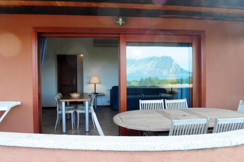 a room with a table and chairs and a view of a mountain at Cala Paradiso Residence in San Teodoro
