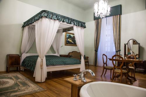 ズノイモにあるAlthanský palácのベッドルーム1室(ベッド1台、バスタブ、テーブル付)