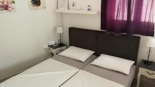 a bedroom with a bed with two white pillows at City Center Room Olivia in Hvar