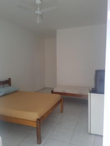 a room with two beds and a tv in it at Suite Recanto Cheiro Verde in Caraguatatuba