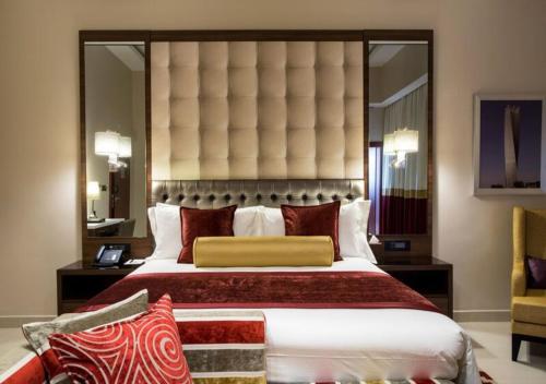a bedroom with a large bed with a large headboard at The Envoy Hotel Abuja in Abuja