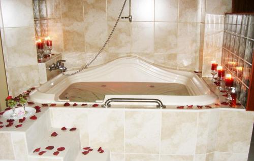 a bath tub in a bathroom with red candles at Hotel Villa Rita Chiclayo in Chiclayo