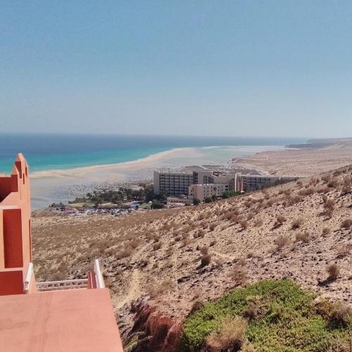 a view of the beach from a building on a hill at Relax, descanso y una experiencia inolvidable in Costa Calma