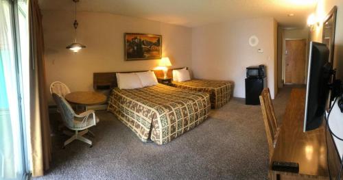 六月湖的住宿－Boulder Lodge，酒店客房设有两张床、一张桌子和电视。