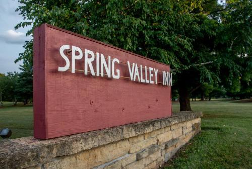 a sign for a spring valley inn on a brick wall at Spring Valley Inn in Spring Green