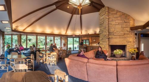 a living room with people sitting on couches and a fireplace at Spring Valley Inn in Spring Green