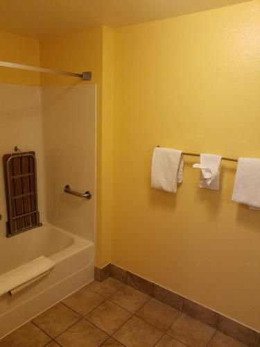 a bathroom with a tub and a sink and towels at Travelodge by Wyndham Wenatchee in Wenatchee