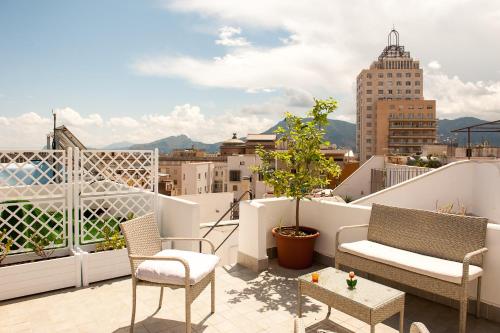 balcón con sillas y vistas a la ciudad en La Terrazza su Palermo, en Palermo