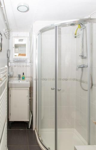 a bathroom with a shower and a sink at Half-pint Cottage in Stroud