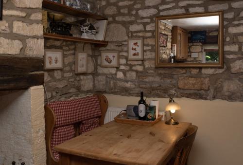 a room with a wooden table and a mirror at Half-pint Cottage in Stroud