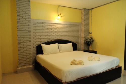 a bedroom with a bed with two towels on it at Puangpech Hotel Lampang in Lampang
