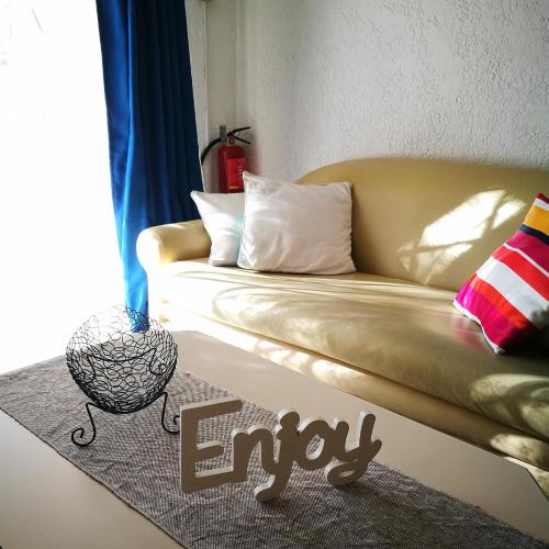 a living room with a couch with pillows on it at OUR ISLAND HOME 5 MINS WALK TO BEACH in Flic-en-Flac