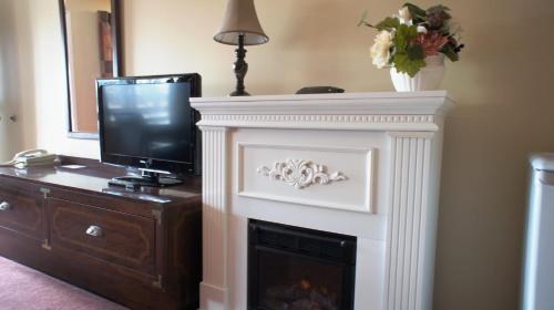 a fireplace with a tv on top of it at Kings Inn Near the Falls in Niagara Falls