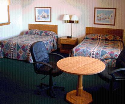 a hotel room with a table and a bed and a desk at Skyline Motel in Alexandria