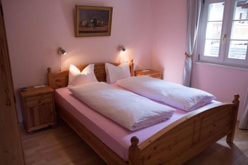 a bedroom with a bed with white sheets and a window at Palazzo Gamboni Swiss Historic Hotel in Comologno