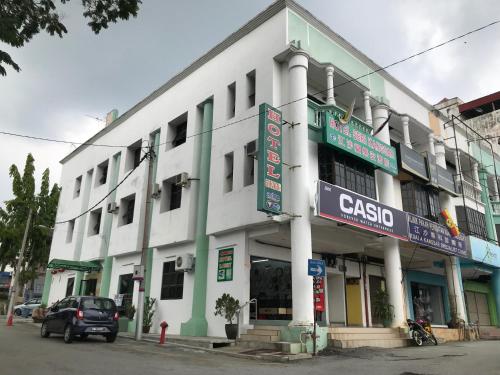 a white building with a car parked in front of it at Hotel Seri Kangsar KK Hotel in Kuala Kangsar