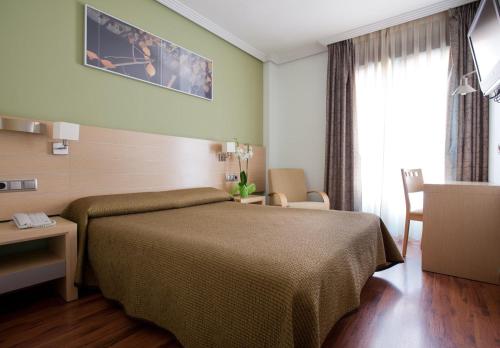 Habitación de hotel con cama, mesa y sillas en 4C Bravo Murillo en Madrid