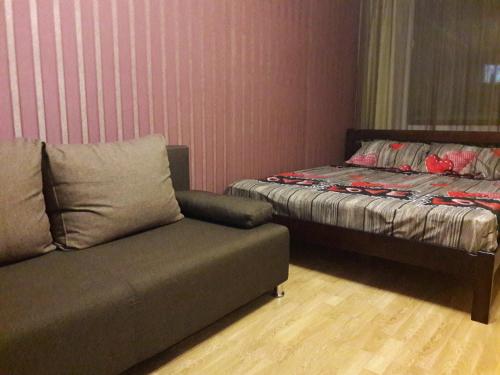 a living room with a couch and a bed at Апартаменты в центре in Chernihiv