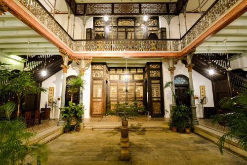 an ornate building with a lobby with plants at Cheong Fatt Tze - The Blue Mansion in George Town