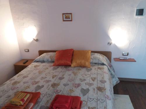 um quarto com uma cama com duas almofadas em B&B Gli Archi em Sìnnai
