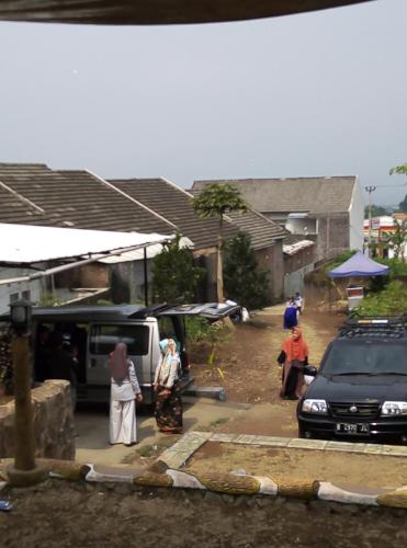 a group of people standing in a street with a car at Hazza syaria homestay in Garut