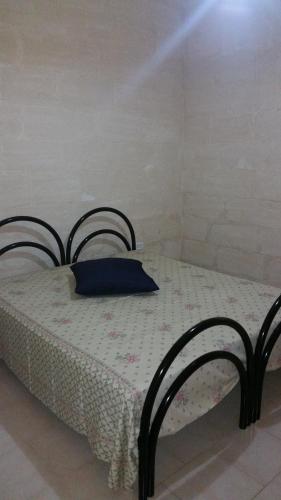 a bedroom with a bed with a blue pillow on it at Casa Vacanza Via Lazio in Torre Lapillo