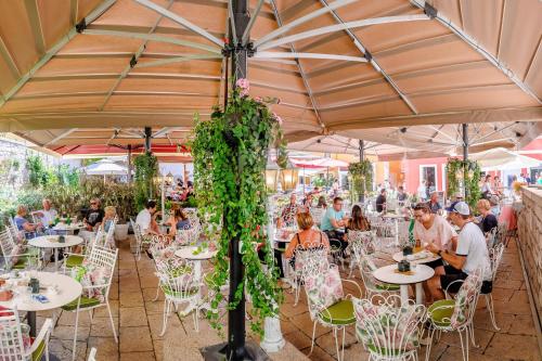 a group of people sitting at tables under a tent at Heritage Hotel Life Palace in Šibenik