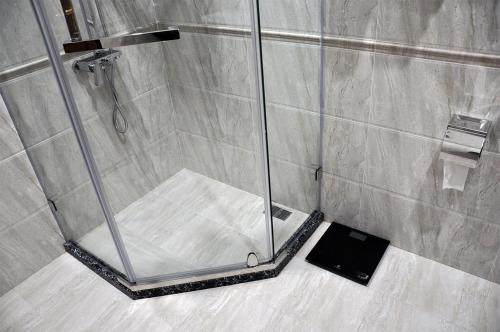 a shower stall with a cell phone on a counter at Parliament Palace Hotel in Khujand
