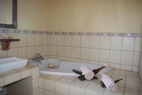 uma casa de banho com banheira e 2 toalhas em Les 3 Marulas em Marloth Park