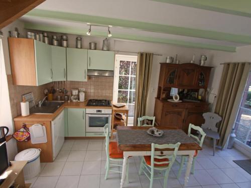 une cuisine avec une table et des chaises ainsi qu'une salle à manger dans l'établissement La grange au tracteur, à Saulcy-sur-Meurthe