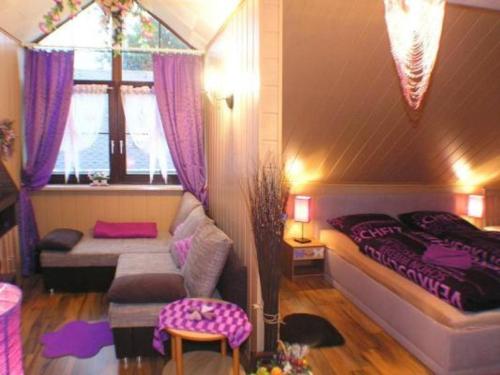 Un dormitorio con una cama y un sofá y una ventana. en Gemütliche Ferienwohnung im Thüringer Wald, nahe des Rennsteigs - pure Erholung, en Schmiedefeld am Rennsteig