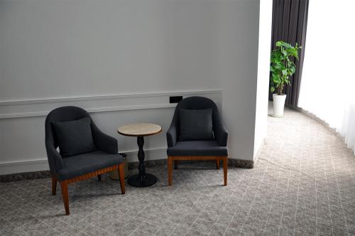 two chairs and a table in a room at Parliament Palace Hotel in Khujand