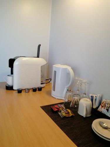 a table with a toaster and a coffee maker and plates at Banjo Paterson Motor Inn in Lakes Entrance