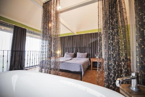 ein Schlafzimmer mit einem Bett und einem großen Fenster in der Unterkunft Chateau Mere in Telawi