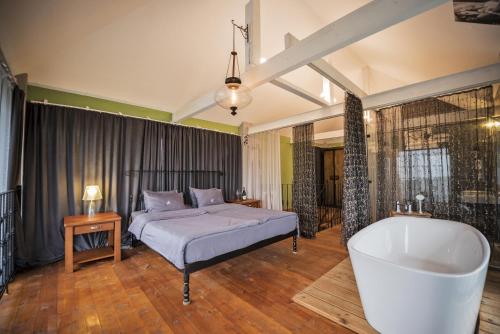 ein Schlafzimmer mit einem Bett und einer Badewanne in der Unterkunft Chateau Mere in Telawi
