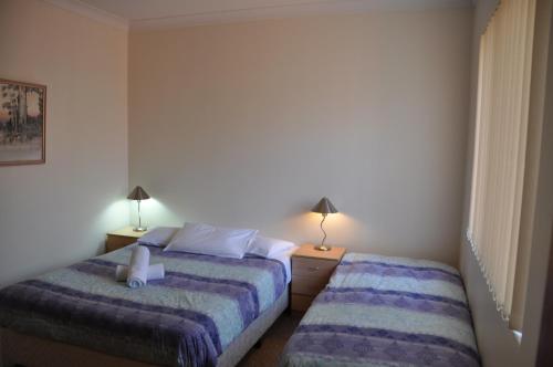 a bedroom with two beds and two lamps at Accommodation Sydney Kogarah 2 bedroom apartment with balcony in Sydney