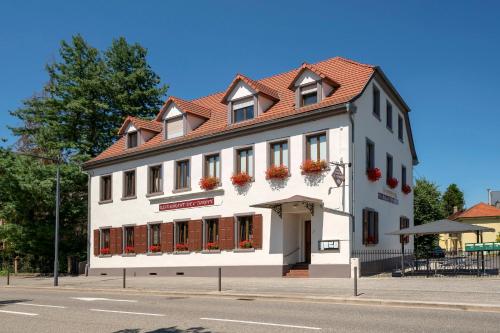 a white building with a red roof on a street at Hotel Restaurant de l'Europe in Wissembourg