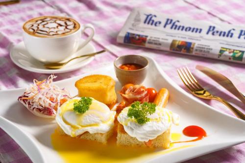 a plate of food with eggs and carrots and a cup of coffee at Sabara Angkor Resort & Spa in Siem Reap