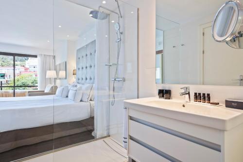 y baño con cama, lavabo y ducha. en Meliá Palma Marina en Palma de Mallorca