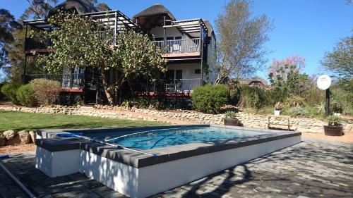 a swimming pool in front of a house at Mountain View Swellendam in Swellendam