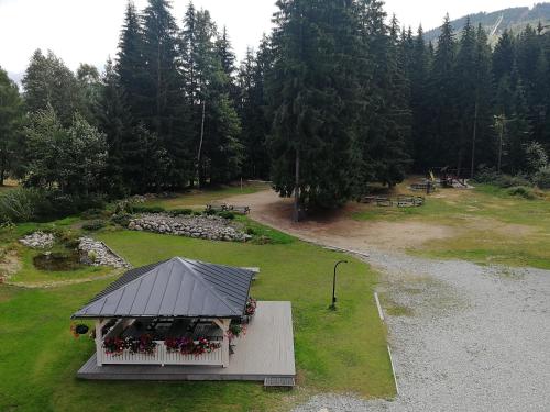 a small building with a black roof and flowers at Penzion Bílá voda in Harrachov