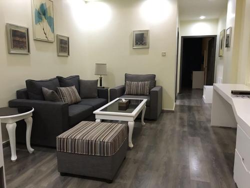 a living room with a couch and a table at Golden Bujari AlUlaya Hotel in Al Khobar