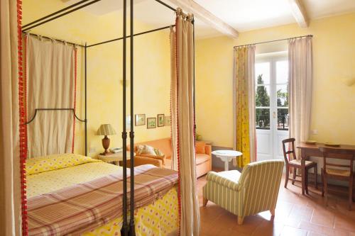 a bedroom with a four poster bed and a chair at Sette Querce in San Casciano dei Bagni